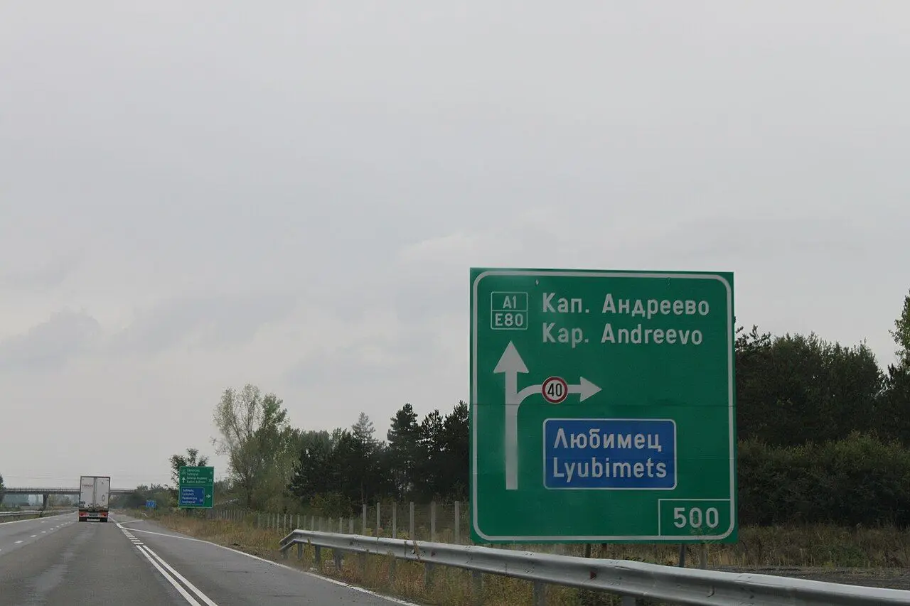 Green direction sign for Kapitan Andreevo on the A1 motorway, with a truck ahead.