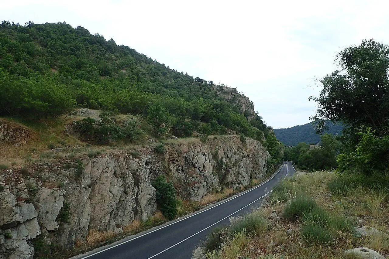 The two-lane road through Kresna Gorge, pressed against a limestone cliff.
